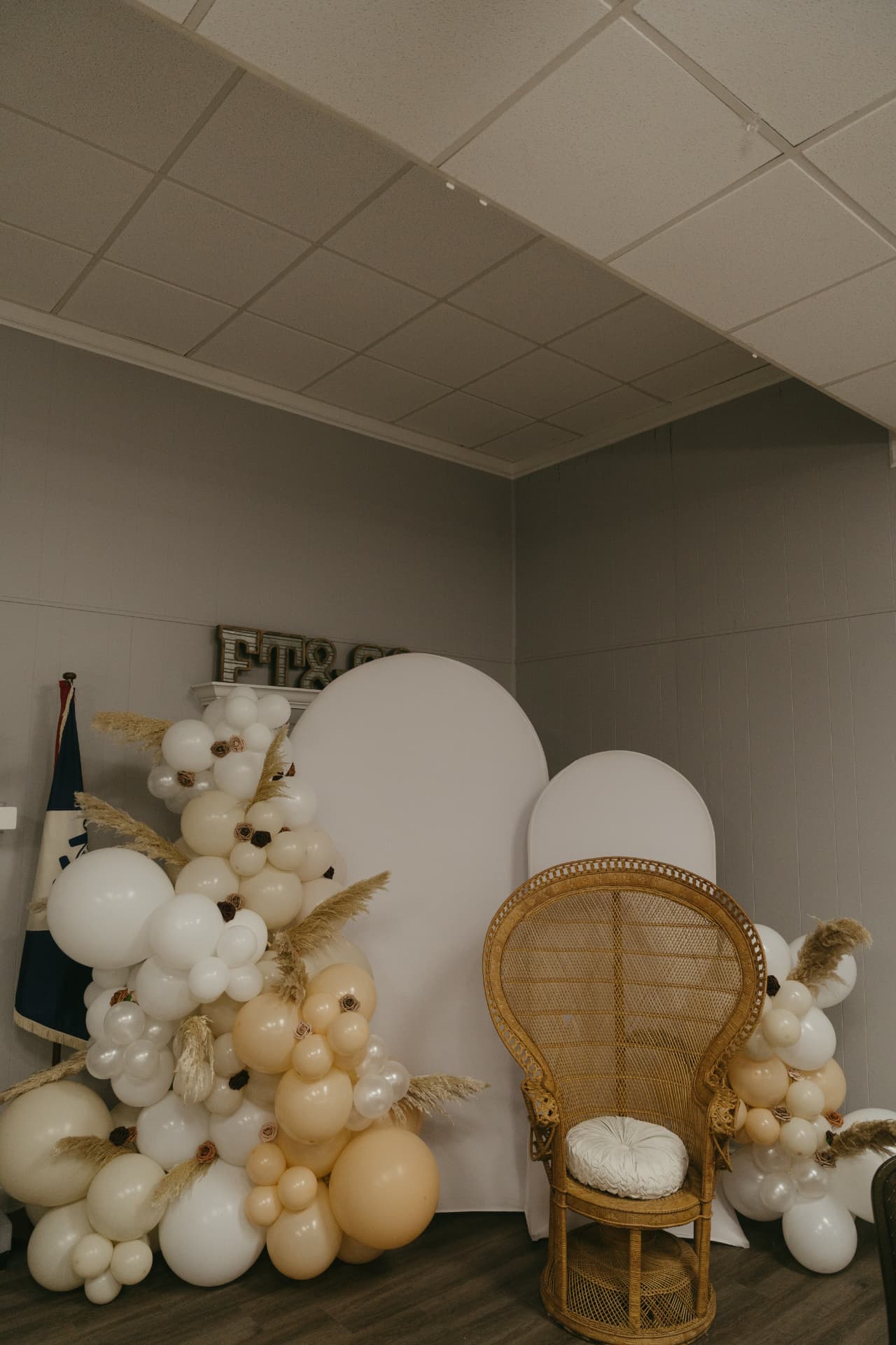 Woven peacock chair with neutral balloon garlands and pampas accents