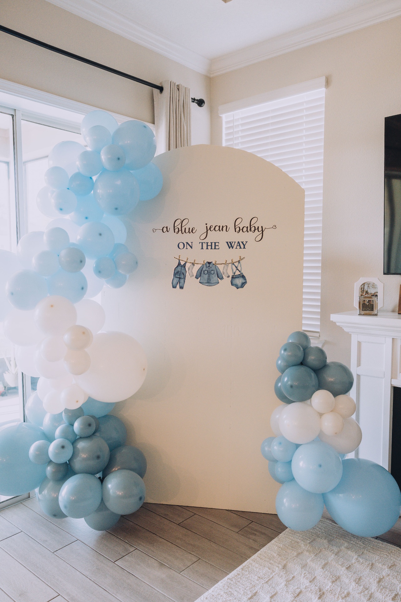 Blue jean baby themed backdrop with balloon garlands in blue and white